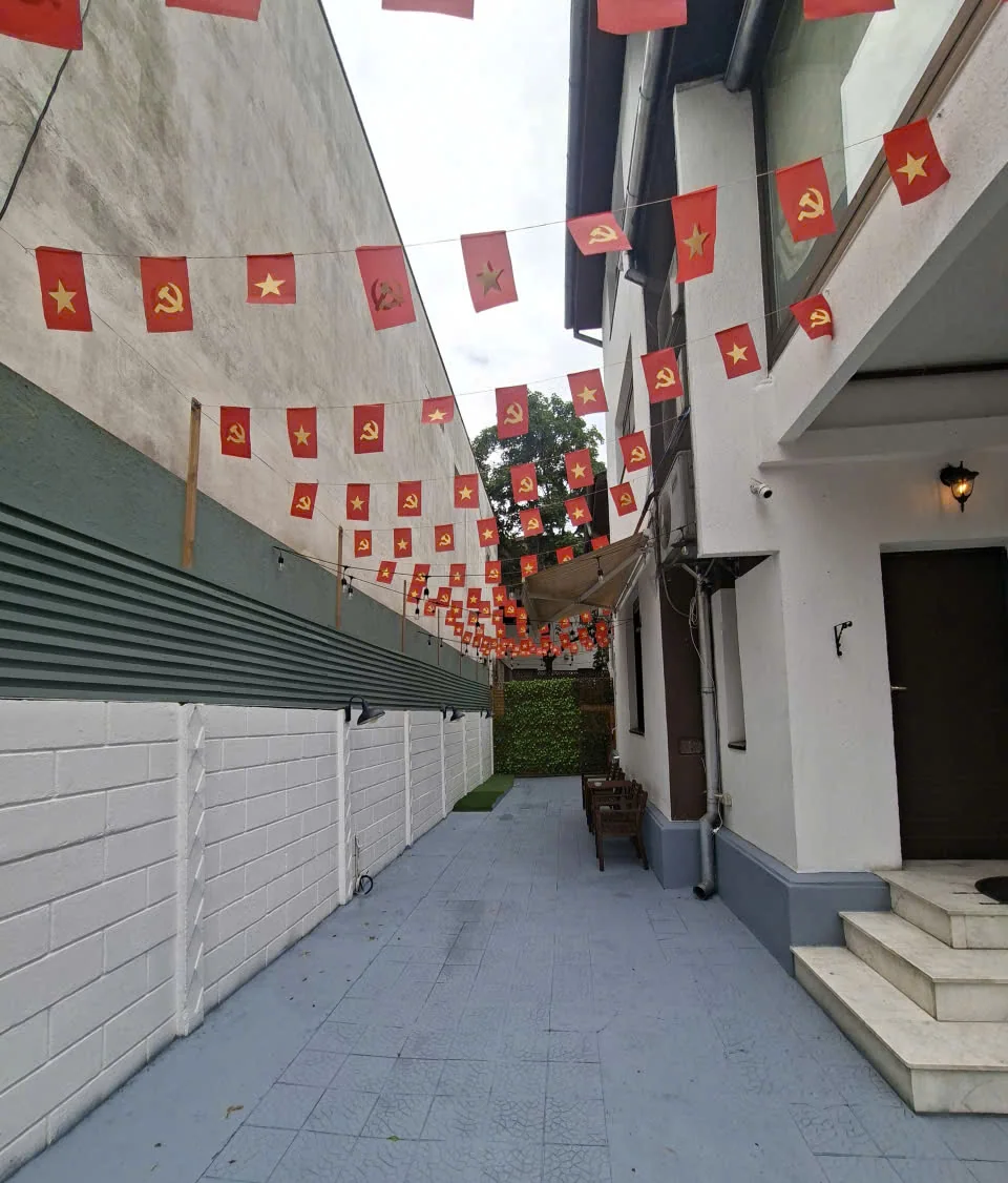 Aleea de intrare decorată cu steaguri vietnameze